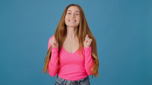 Porträt einer extrem glücklichen, positiven Frau, die sich mit erhobenen geballten Fäusten freut und im Lotto gewinnt