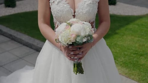 Bride Holding Wedding Bouquet in Sunlight