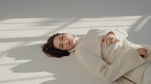 Woman in Cream Sweater Posing on White Surface