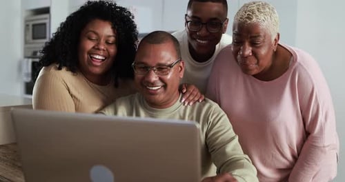 Smiling Family Video Chatting on Laptop at Home
