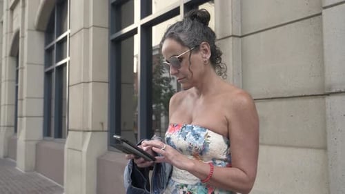 Beautiful Woman in Strapless Dress Using Smart Phone on City Sidewalk Adult