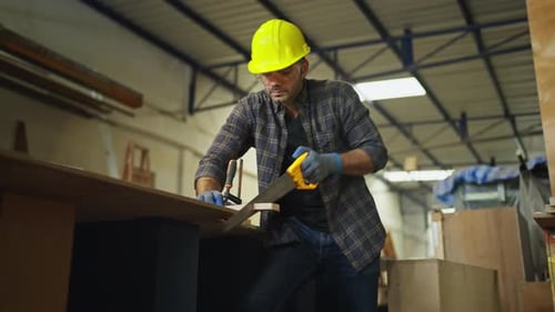 Lower view of professional carpenter or woodworker or charpentier man use saw to cut wood stick