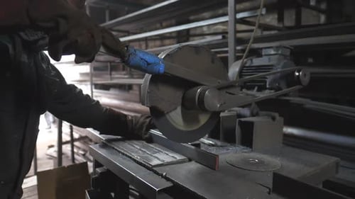 Machine Operator Cuts Metal Bar With Sparks