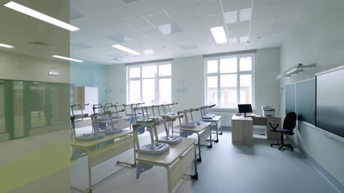 Das Klassenzimmer verfügt über Schreibtischreihen und ein interaktives Whiteboard