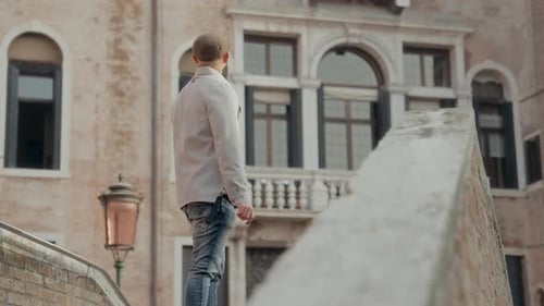 Man Exploring Venice Before Descending Bridge