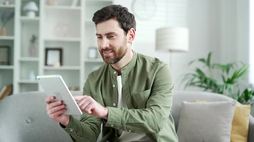 Man Relaxing at Home Using Tablet Device