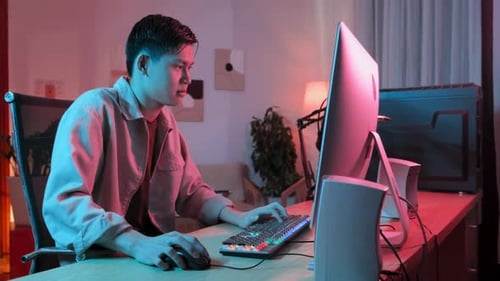 Asiatischer Typ spielt Computerspiel