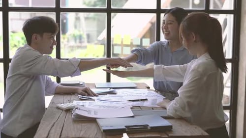 Team Celebrates Success Around Table in Office