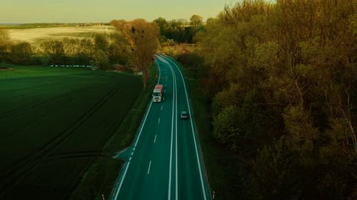 Driving Truck with Cargo Trailer on Rural Highway During Golden Hour Hauling Freight Through Scenic
