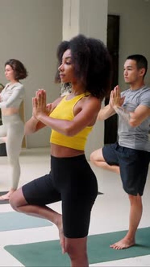 Adults in yoga class practicing tree pose