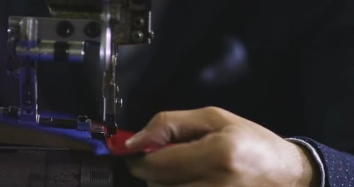 Une jeune main d'un tailleur italien coud ou coupe votre tissu pour en faire un costume sur mesure au ralenti