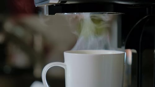Close Up Side View of Hot Black Coffee Pouring From the Machine to White Cup Fresh Cafe in the