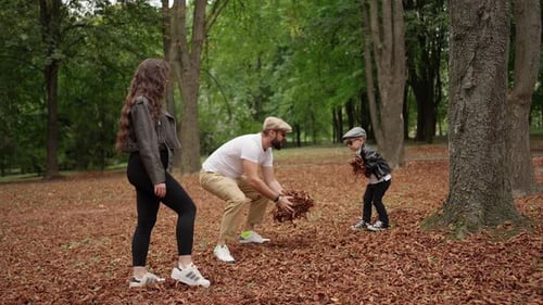 Family Playing with Autumn Leaves in the Park Concept of a Happy Family