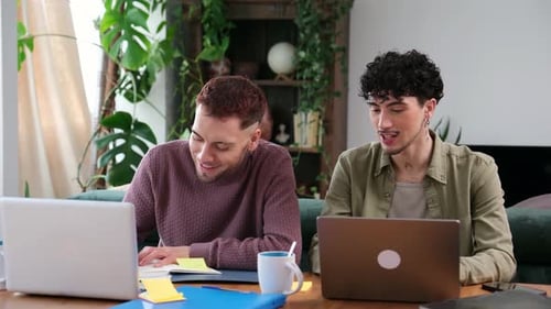 Couple gay collaborant sur un projet de travail à domicile