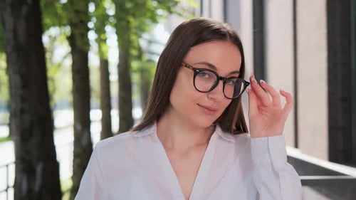 Young Woman Smiling With Glasses in Urban Setting