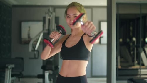 Woman Doing Boxing Workout with Dumbbells in Gym