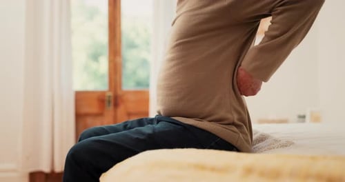 Adult Rubbing Sore Lower Back on Bed