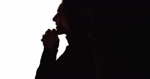 Silhouette of Woman Clasping Hands Against Split Background