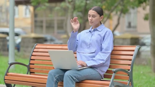 Woman Working on Laptop in Park, Massaging Temple