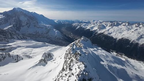 Eine weitläufige Luftaufnahme über eine atemberaubende Alpenlandschaft mit einem scharfen Bergrücken, der dazu führt