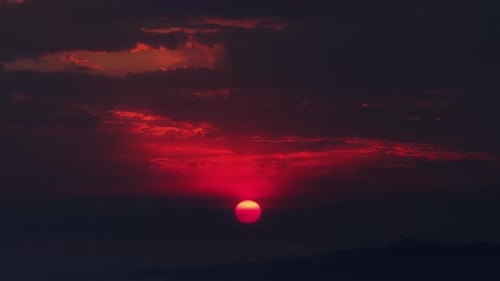 Dramatic Sunset Over Distant Mountains and Clouds