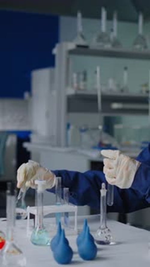 Scientist Working with Beakers and Test Tubes in Lab