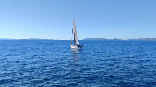 Graceful Sailboat Cruising Through Azure Mediterranean Waters