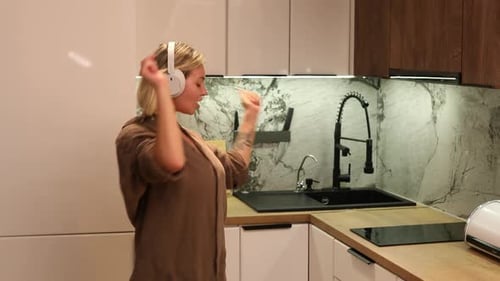 Woman Dancing to Music in Modern Kitchen