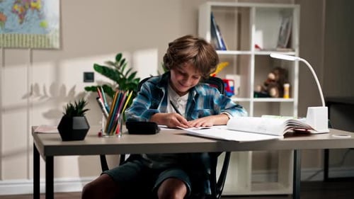 Boy Happily Doing Homework in His Room