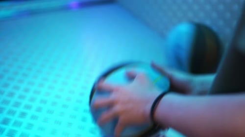Young Male Player Engaging in Competitive Basketball Arcade Game with Vibrant Lighting Effects