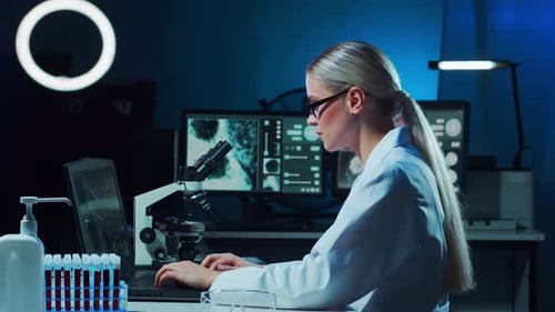Female Scientist Working in a Dark Lab
