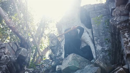 Person in Mask Holds Sword in Stone Ruins