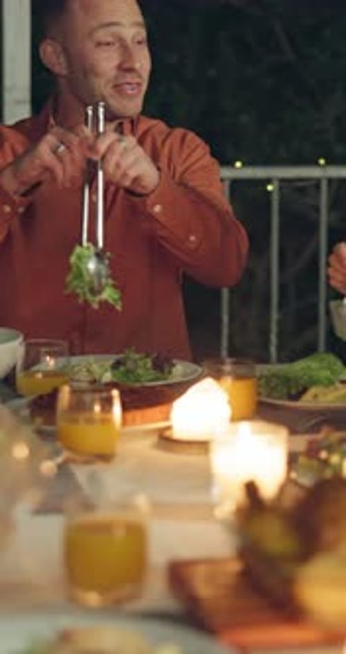 Friends Enjoying Candlelit Dinner Party at Night