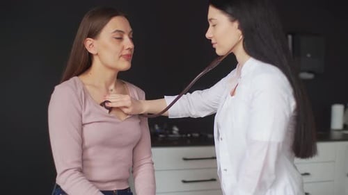Female Doctor Examines Patient with Stethoscope in Clinic