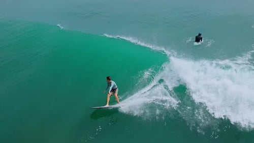 High Above View Showcasing Surfer Balancing On Crest Of Vibrant Blue Wave