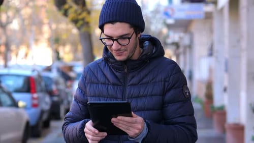 Young Adult Using Tablet Outdoors in Urban Setting