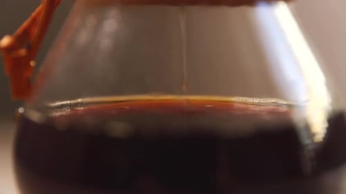 Dripping coffee into container looking at the bottom of a glass container when you see a stream of c