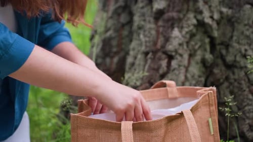 Primer plano de una mujer devolviendo un aro bordado a una bolsa al aire libre