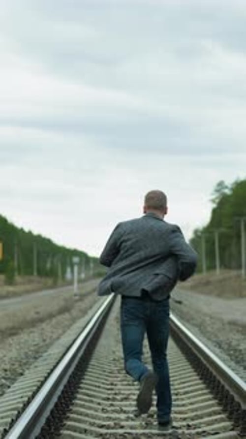 Man Running on Train Tracks in the Country