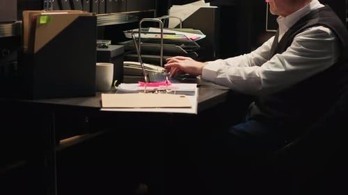 Man Typing At Desk in Dark Office
