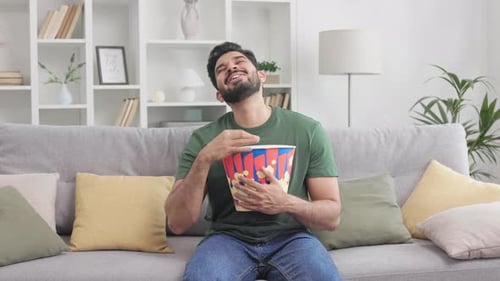 Young Indian Guy Watching Comedy and Eating Popcorn at Home