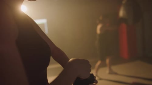 Woman Wrapping Hands in Boxing Gym
