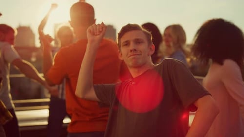 Happy Young Adults Dancing at Rooftop Party Sunset