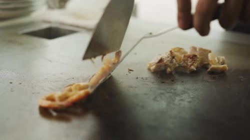 Teppanyaki Chef Cooking Shrimps And Meat On Griddle Using Spatula. - close up