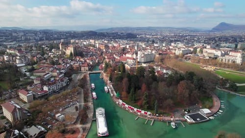 Annecy, France. Long aerial of old town skyline, canals and lakefront,