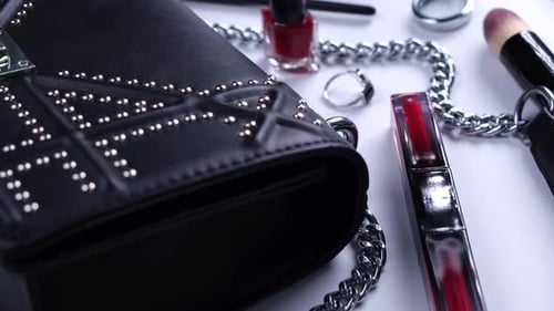 Background with Trendy Black Handbag and Decorative Cosmetics Nail Polish Makeup Brushes Eyelash or