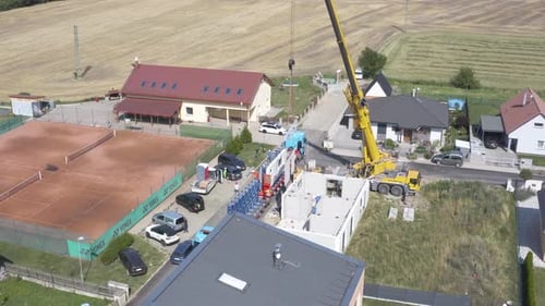 Grúa de construcción móvil que instala un panel de construcción desde un camión.