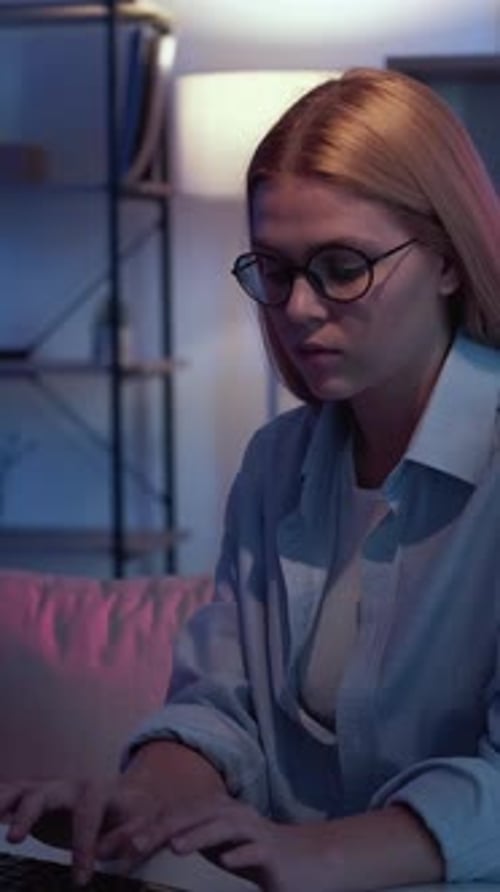 Woman Typing at Computer Keyboard in Home at Night