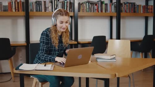 Young Girl College Student Sit at Desk Use Pc Laptop Computer in Library Woman in Headphones Uses