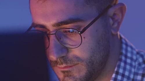 Close-up of Focused Man Working at Night